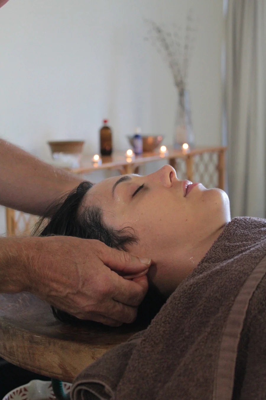 A person resting while receiving a head massage
