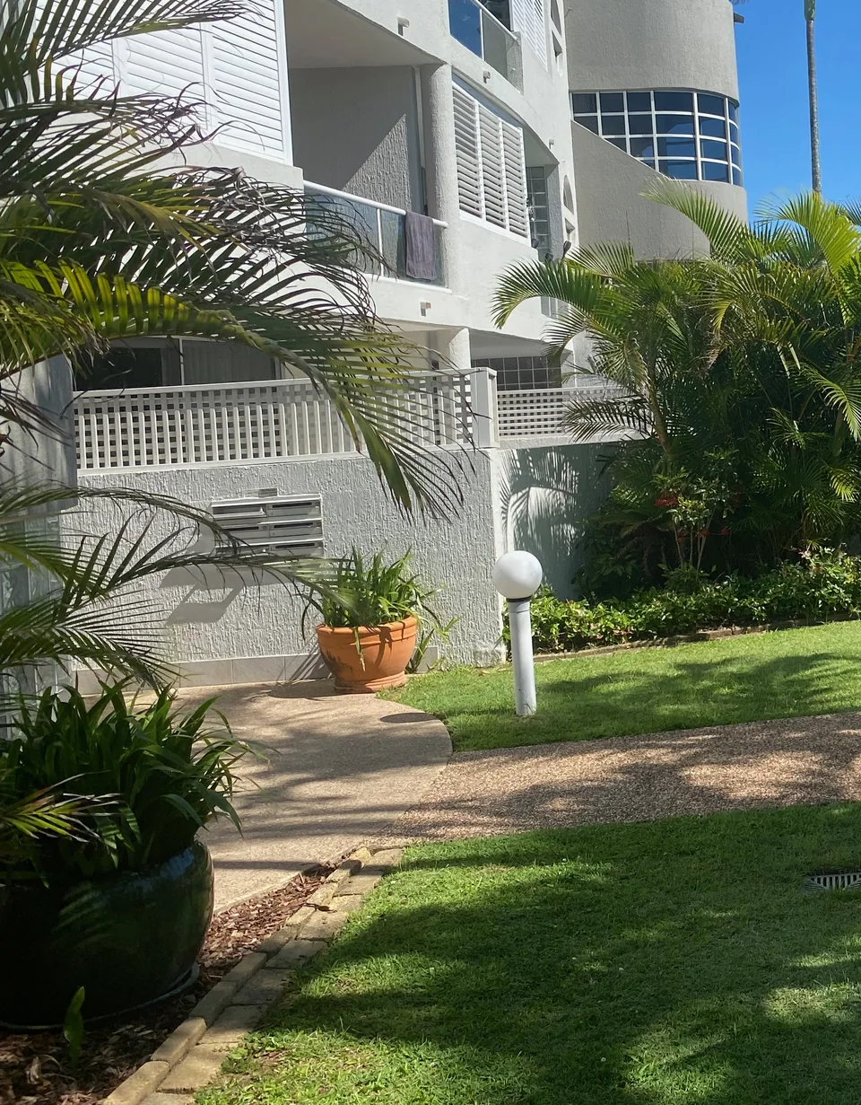 Palms and lawn beside the garden path at the apartment resort